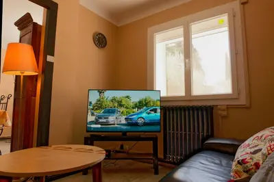a living room with a flat screen tv in a room at Le Logis d'Aude in Carcassonne
