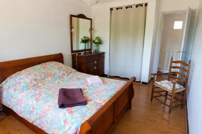 a bedroom with a bed and a mirror and a chair at Le Logis d'Aude in Carcassonne