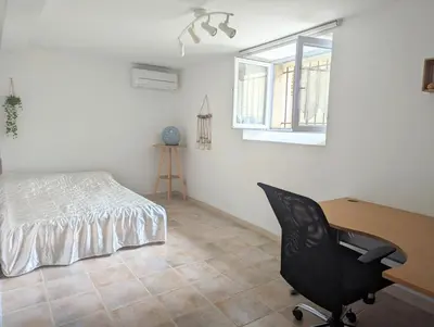 a bedroom with a desk and a bed and a chair at Chambre climatisée 2 places plus une place Bébé 0-3 ans, salle de bain et WC en espace privatif in La Livinière