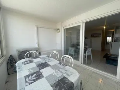 a dining room with a table and chairs in a house at 150 MARINA BAY CAP D'AGDE Quartier Falaises proche plage T2 cabine avec place de parking et piscine in Laure-Minervois