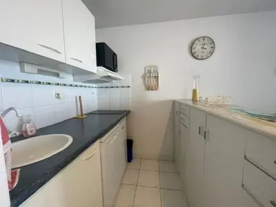 a bathroom with a sink and a clock on the wall at 150 MARINA BAY CAP D'AGDE Quartier Falaises proche plage T2 cabine avec place de parking et piscine in Laure-Minervois