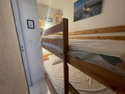 a bedroom with two bunk beds in a room at 150 MARINA BAY CAP D'AGDE Quartier Falaises proche plage T2 cabine avec place de parking et piscine in Laure-Minervois