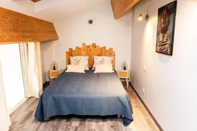 a bedroom with a large bed with a wooden headboard at Duplex moderne centre Narbonne in Narbonne