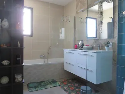 a bathroom with a sink and a tub and a shower at L'hibiscus in Narbonne