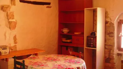 a room with a table and a chair and a microwave at Petit gite rustique et économique in Albas