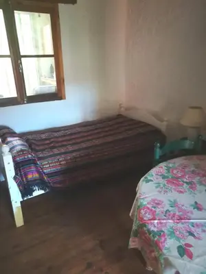 a bedroom with a large couch in the corner of a room at Petit gite rustique et économique in Albas