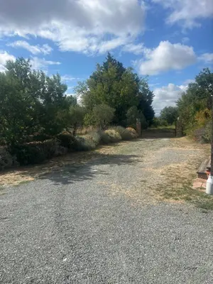 a gravel road with trees on the side of it at Cottage atypique avec piscine & accès au lac 6 personnes in Molleville