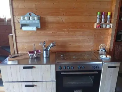 a kitchen with a stove and a counter top at Cottage atypique avec piscine & accès au lac 6 personnes in Molleville
