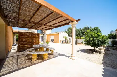 a wooden pergola with a picnic table on a patio at Casa Sacha - Appt avec piscine partagée in Fitou