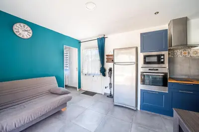 a kitchen with a couch and a blue wall at Casa Sacha - Appt avec piscine partagée in Fitou