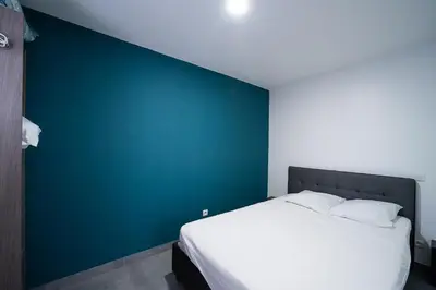 a bed in a room with a blue wall at Casa Sacha - Appt avec piscine partagée in Fitou