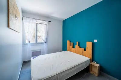 a bedroom with a bed with a blue wall at Casa Jade - Appt pour 4 in Fitou