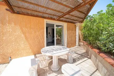 a patio with a table and a wooden pergola at Casa Jade - Appt pour 4 in Fitou