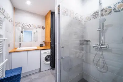 a bathroom with a shower and a washing machine at Casa Jade - Appt pour 4 in Fitou