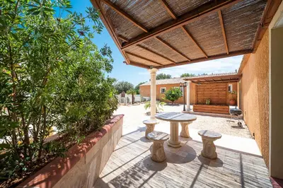 a patio with a table and stools under a pergola at Casa Jade - Appt pour 4 in Fitou