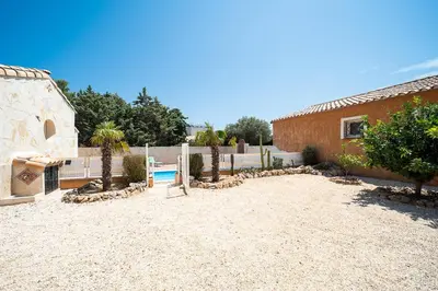 a backyard with a pool and a building and trees at Casa Jade - Appt pour 4 in Fitou