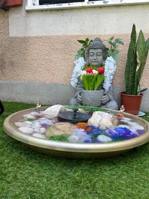 a statue of a buddha sitting next to a fountain at Studio jacuzzi à l'abri des vents in Carcassonne