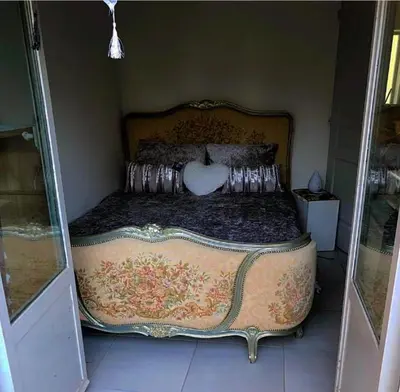 a bedroom with a large bed with a ornate frame at Studio jacuzzi à l'abri des vents in Carcassonne