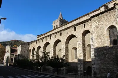 a large brick building with a tower on top of it at Appartement le petit bonheur in Saint-Pons-de-Thomières