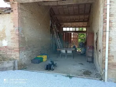 a room with a table and chairs and a brick wall at Maison Lauraguaise parking grand jardin wifi in Villenouvelle