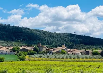 a village in the middle of a field with a mountain at Superbe maison de village et sa terrasse panoramique in Oupia
