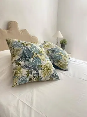 a white bed with two pillows on top of it at Superbe maison de village et sa terrasse panoramique in Oupia