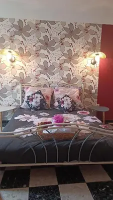 a bed in a room with a floral wall at A L' Estiu in Latour-de-France