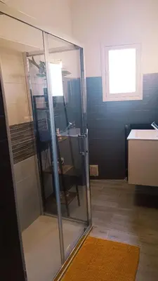 a glass shower in a bathroom with a sink at A L' Estiu in Latour-de-France