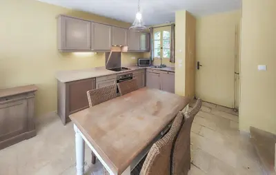 a kitchen with a wooden table and chairs at Pet Friendly Home In Saint Laurent De La Ca in Saint-Laurent-de-la-Cabrerisse