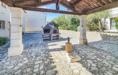 a stone patio with a fireplace in a building at Pet Friendly Home In Saint Laurent De La Ca in Saint-Laurent-de-la-Cabrerisse