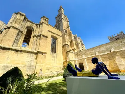 a statue of a woman sitting in front of a building at Le Jardin de la Cathédrale - T2 - Centre Ville - Emplacement & Vue Extraordinaires in Narbonne