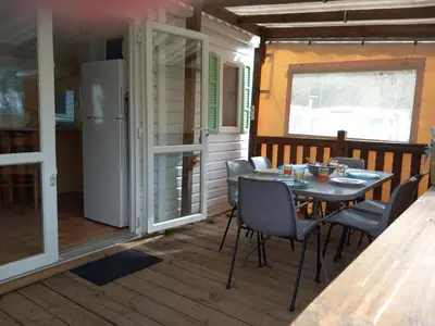 a table and chairs on the porch of a tiny house at Mobil-home Riviera in Vaudreuille
