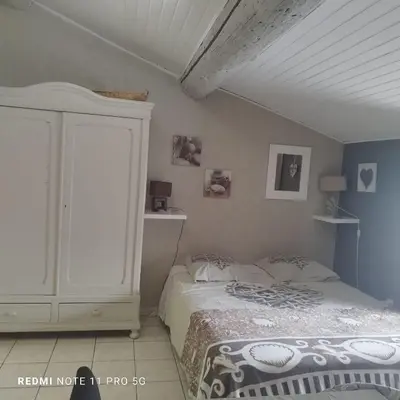 a bedroom with a bed and a white cabinet at Charmant T3 de 65 m2 in Port-la-Nouvelle
