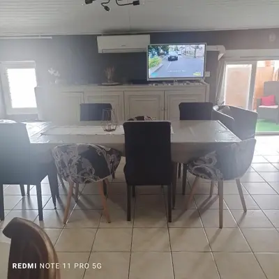 a kitchen with a table and chairs and a tv at Charmant T3 de 65 m2 in Port-la-Nouvelle