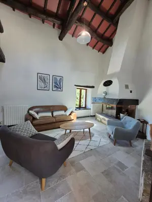 a living room with a couch and a table at Gîte rural 8 à 10 personnes au coeur du Parc National du Haut Languedoc in Saint-Pons-de-Thomières