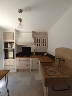 a kitchen with white cabinets and a sink at Gîte rural 8 à 10 personnes au coeur du Parc National du Haut Languedoc in Saint-Pons-de-Thomières