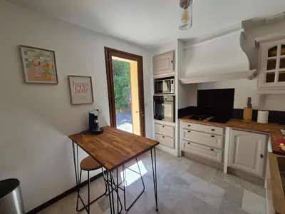 a kitchen with a wooden table and a television at Gîte rural 8 à 10 personnes au coeur du Parc National du Haut Languedoc in Saint-Pons-de-Thomières