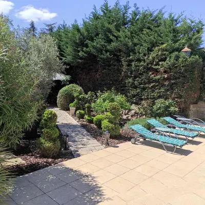 a group of blue lounge chairs in a garden at Villa Angel - SPA in Caunes-Minervois