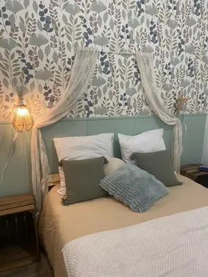 a bed with two pillows on it in a bedroom at Appartement cosy avec oasis privée, salle de jeux, vélos bienvenus in Carcassonne