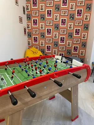 a pool table with avertisement for at Appartement cosy avec oasis privée, salle de jeux, vélos bienvenus in Carcassonne