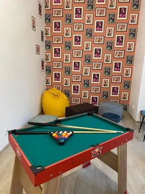 a pool table in a room with a wall of pictures at Appartement cosy avec oasis privée, salle de jeux, vélos bienvenus in Carcassonne