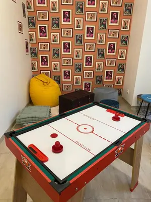 a ping pong table in front of a wall with pictures at Appartement cosy avec oasis privée, salle de jeux, vélos bienvenus in Carcassonne