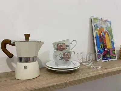 a blender on a shelf with a picture and glasses at Appartement cosy avec oasis privée, salle de jeux, vélos bienvenus in Carcassonne