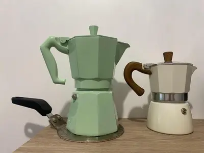 a green coffee maker and a blender on a table at Appartement cosy avec oasis privée, salle de jeux, vélos bienvenus in Carcassonne