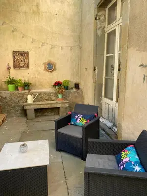 an outdoor patio with two chairs and a table at Appartement cosy avec oasis privée, salle de jeux, vélos bienvenus in Carcassonne
