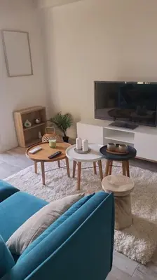 a living room with a blue couch and two tables at La Gruissanaise in Gruissan