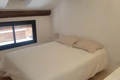a white bed in a room with a window at La Gruissanaise in Gruissan