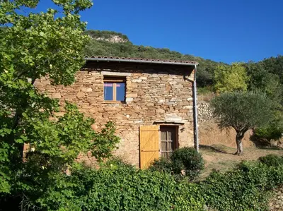 a stone building with a window and a door at Gîte des Orangers in Roquebrun