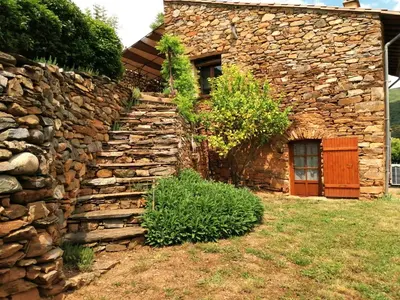 a stone wall in front of a house at Gîte des Orangers in Roquebrun