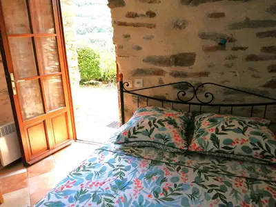 a bed with a pillow next to a door at Gîte des Orangers in Roquebrun